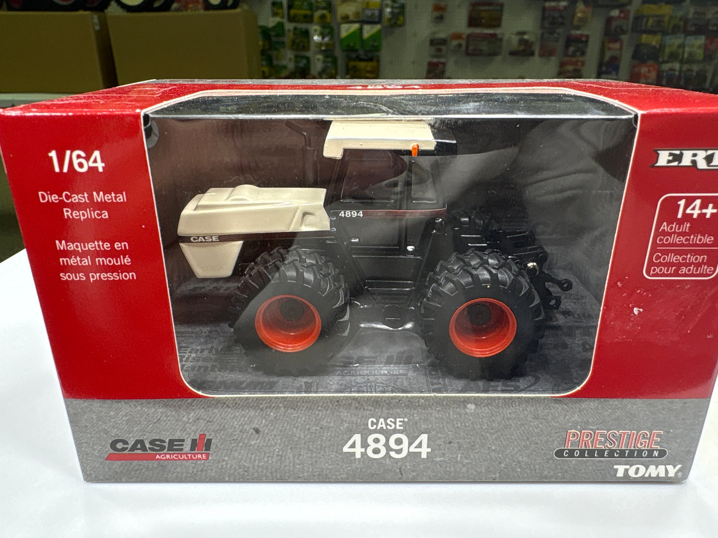 Model tractor in packaging with visible branding on a white background