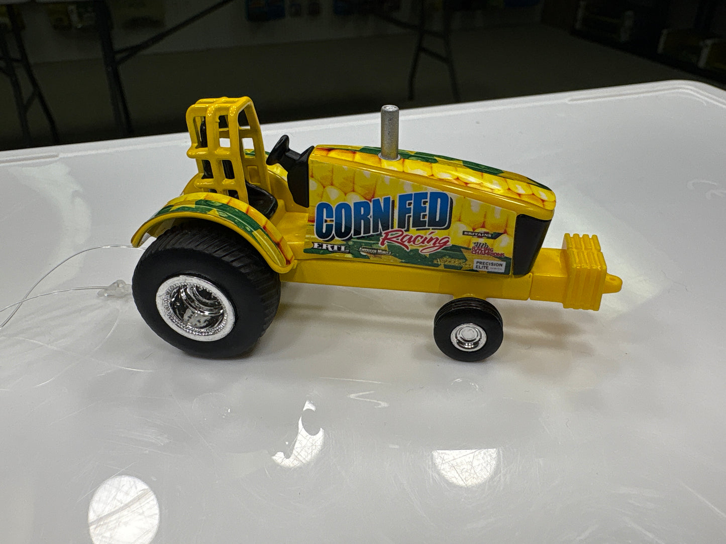 Model tractor with 'Corn Fed Racing' branding on a white surface
