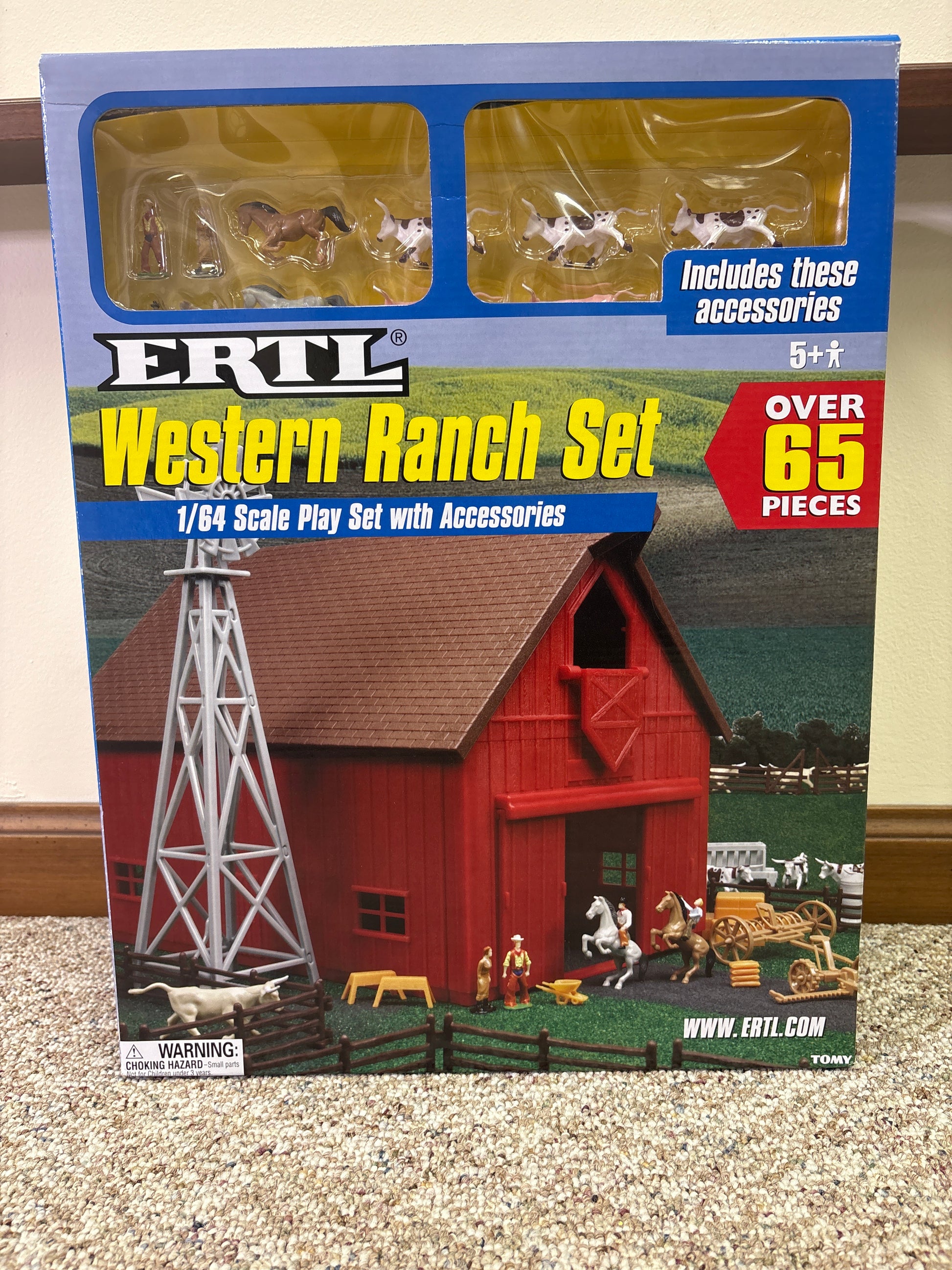 Model western ranch set packaging with red barn and tower on a textured surface