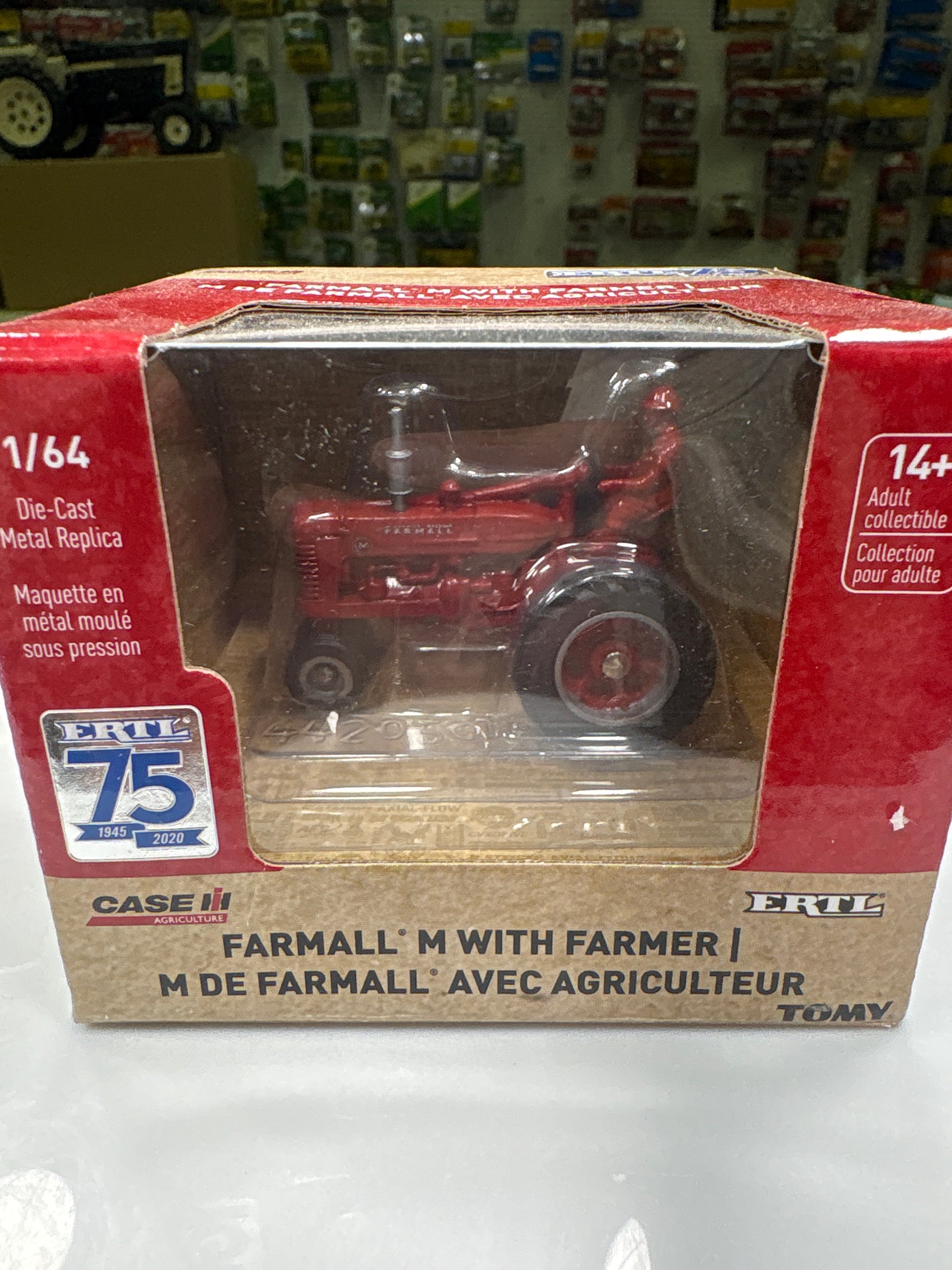 Model tractor in packaging with visible branding on a white background