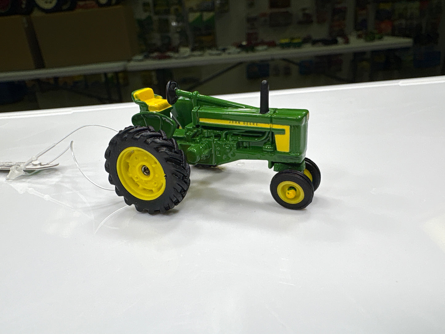 Model tractor on a white surface with a blurred background