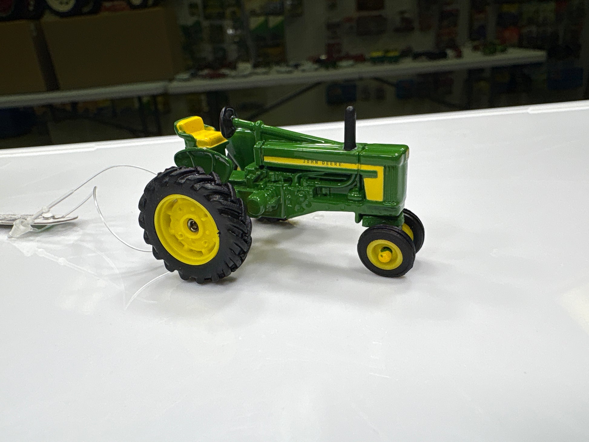 Model tractor on a white surface with a blurred background