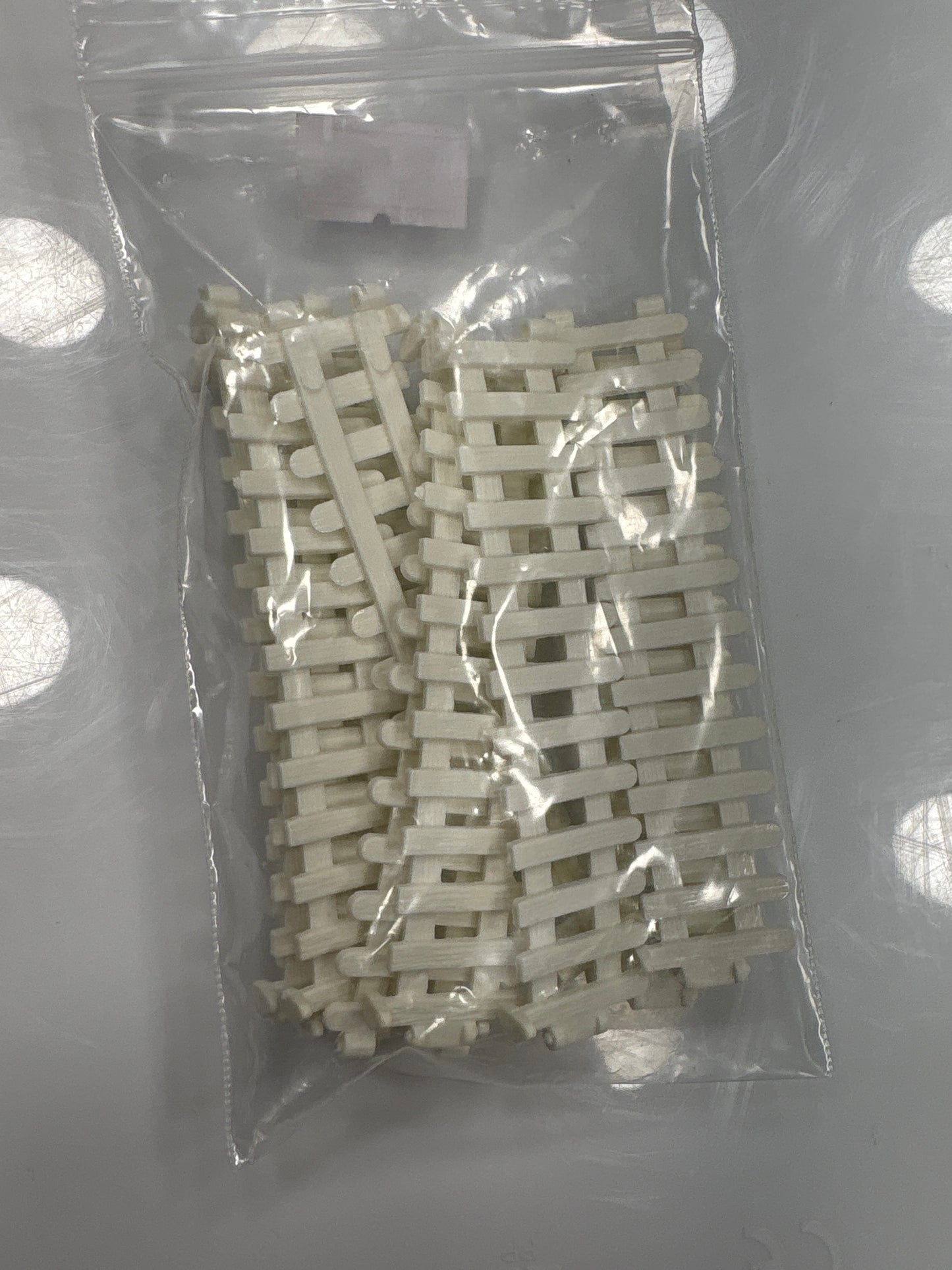 Packaged white plastic interlocking fence on a gray background