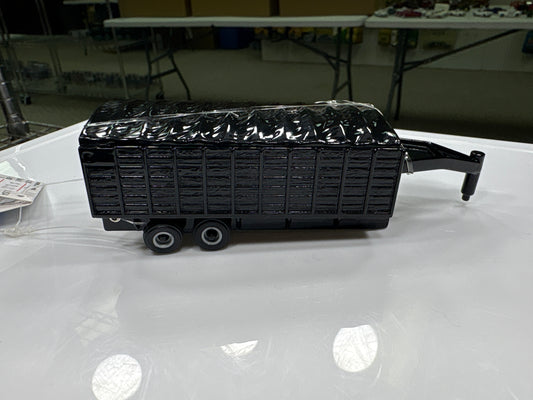 Black trailer model on a white surface with a blurred indoor background